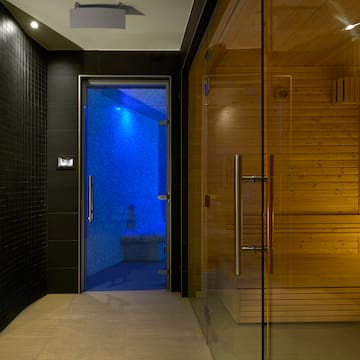 a sauna with a glass door and a wooden bench