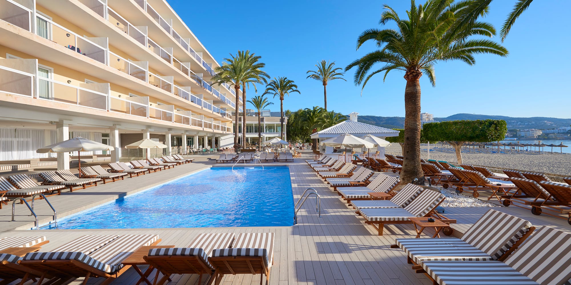 a pool with lounge chairs and palm trees