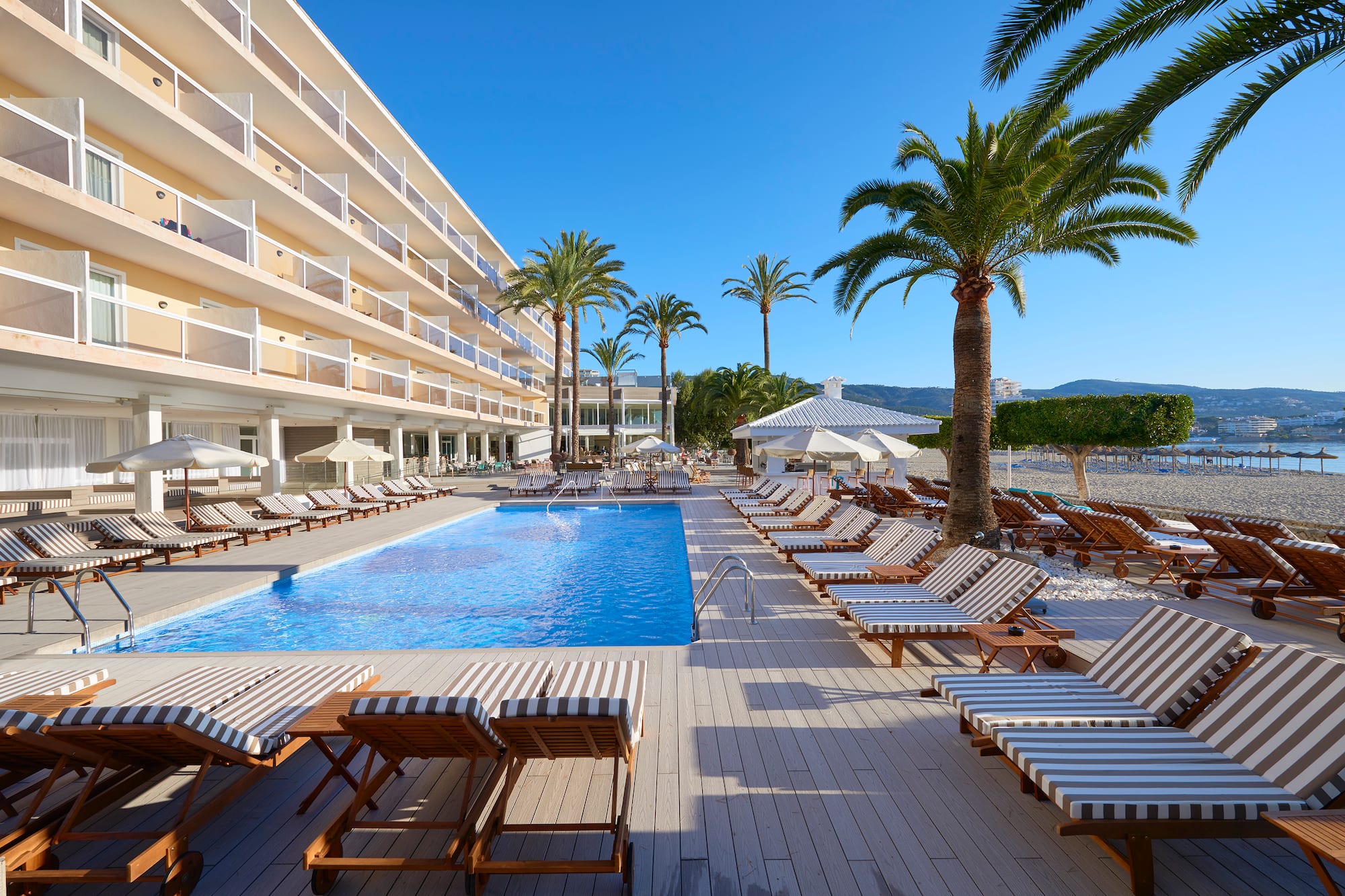 a pool with lounge chairs and palm trees