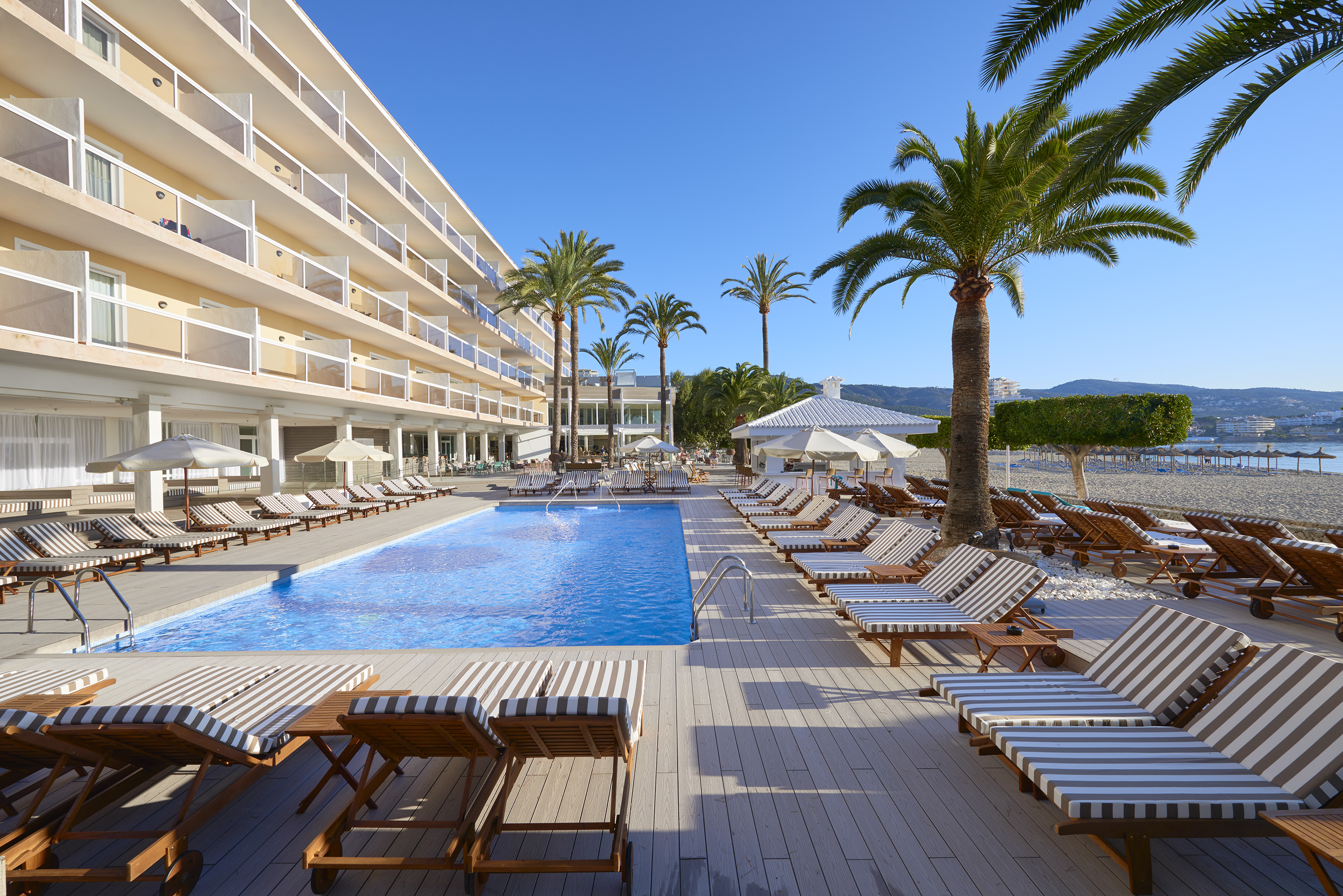 a pool with lounge chairs and palm trees