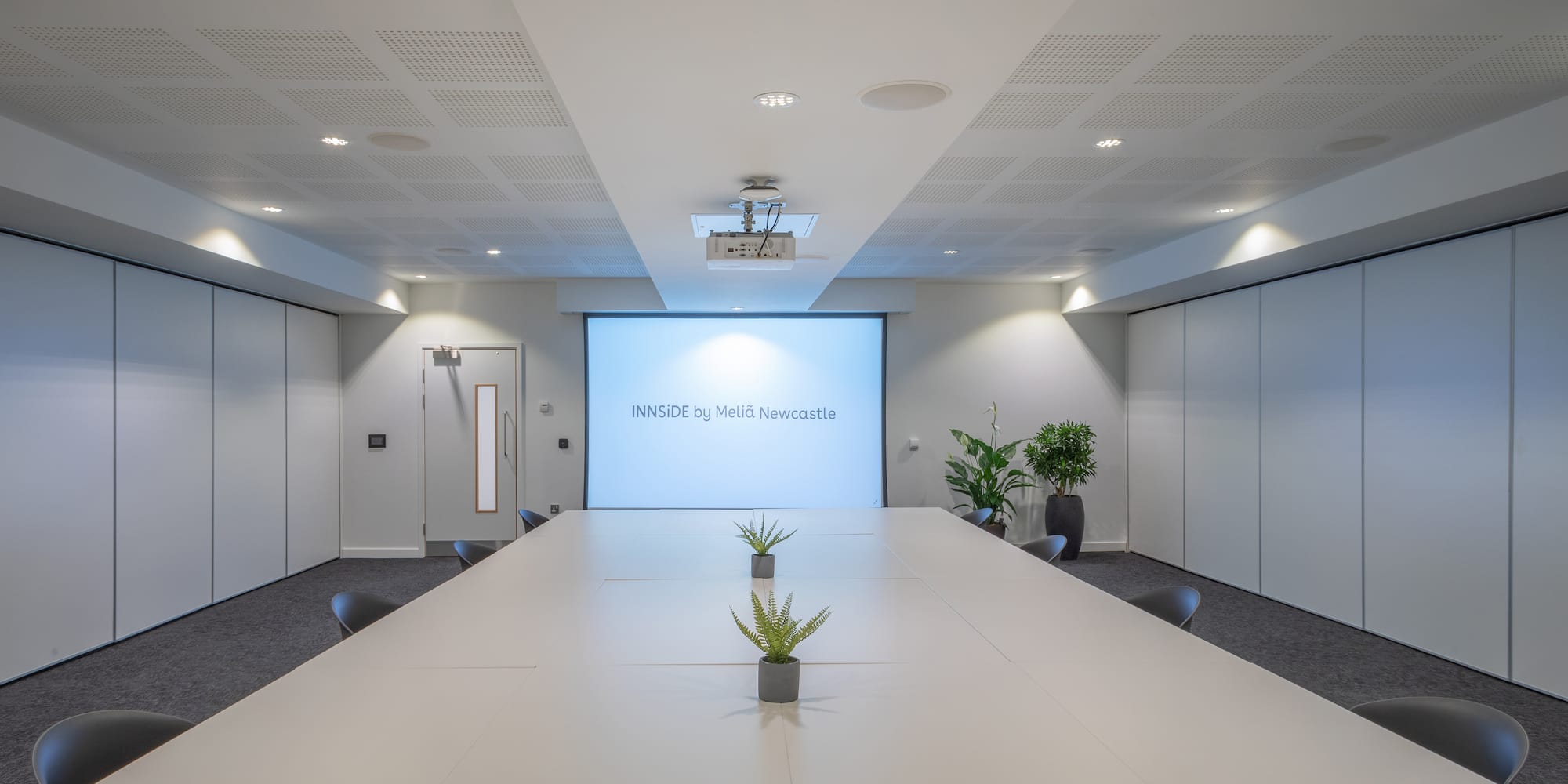 a room with a large table and plants