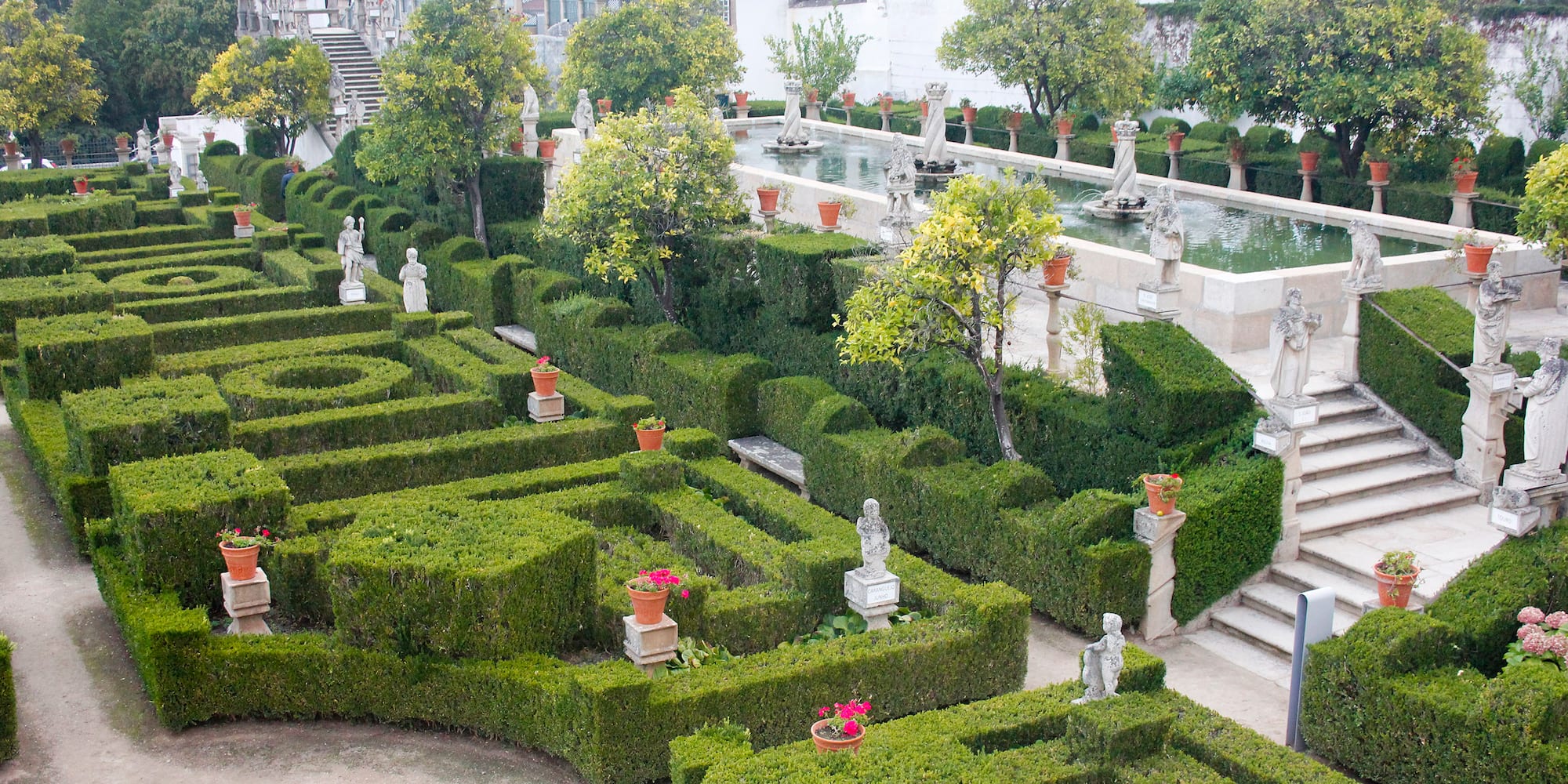 a garden with hedges and statues