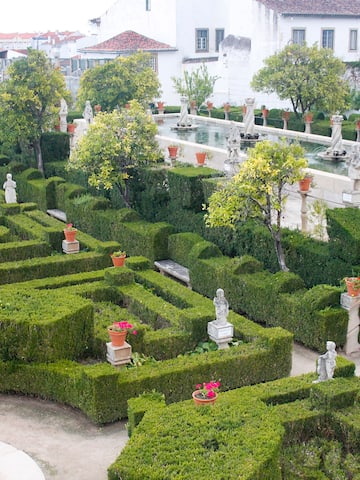 a garden with hedges and statues