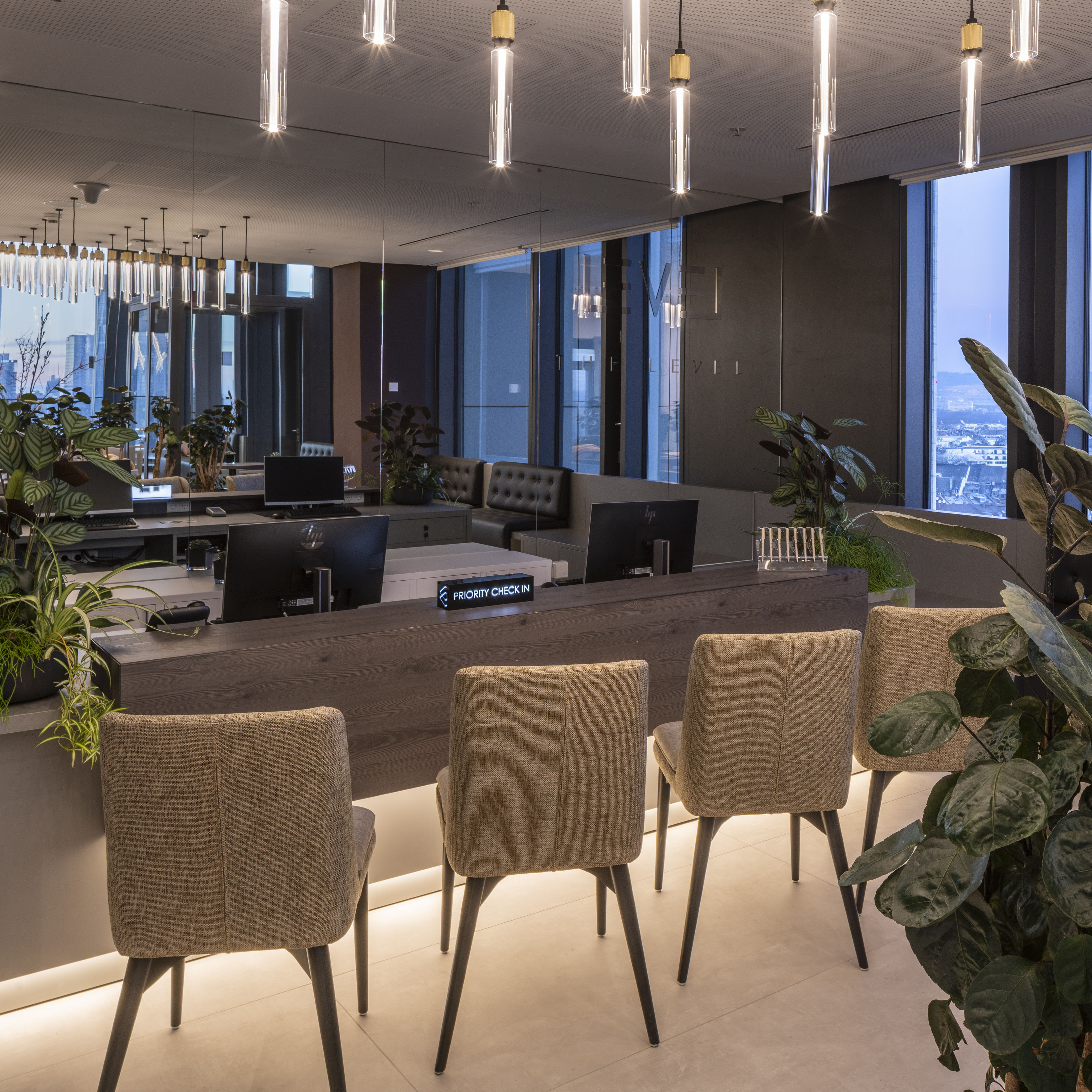 a room with chairs and a table and plants