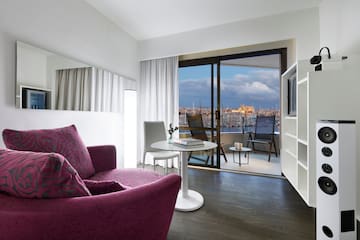 a room with a purple couch and a table and a television