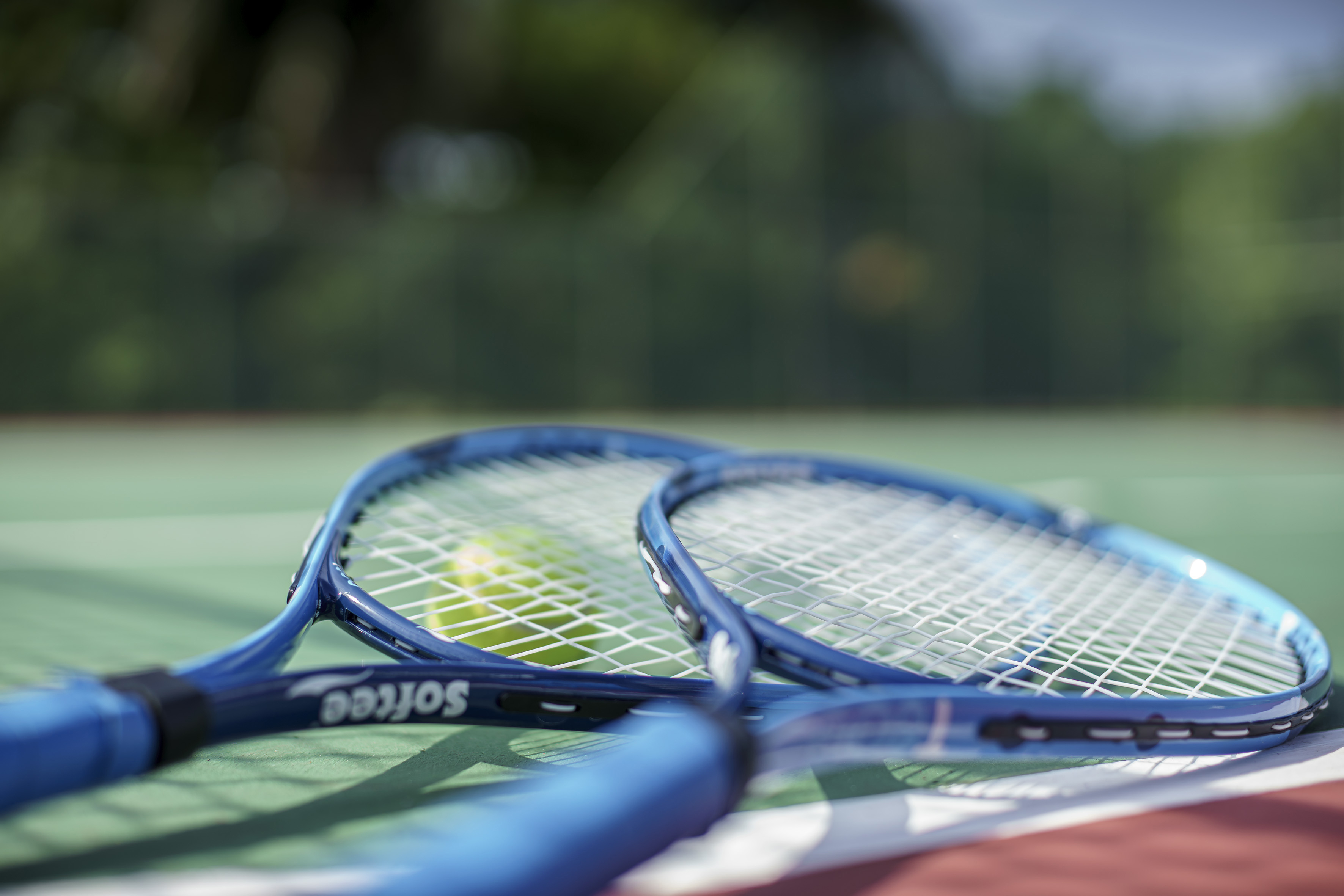 a tennis rackets and a ball on a tennis court