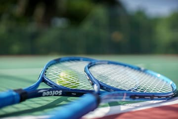 a tennis rackets and a ball on a tennis court