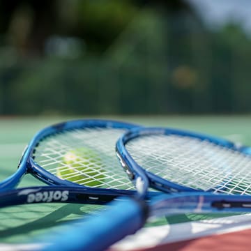 a tennis rackets and a ball on a tennis court