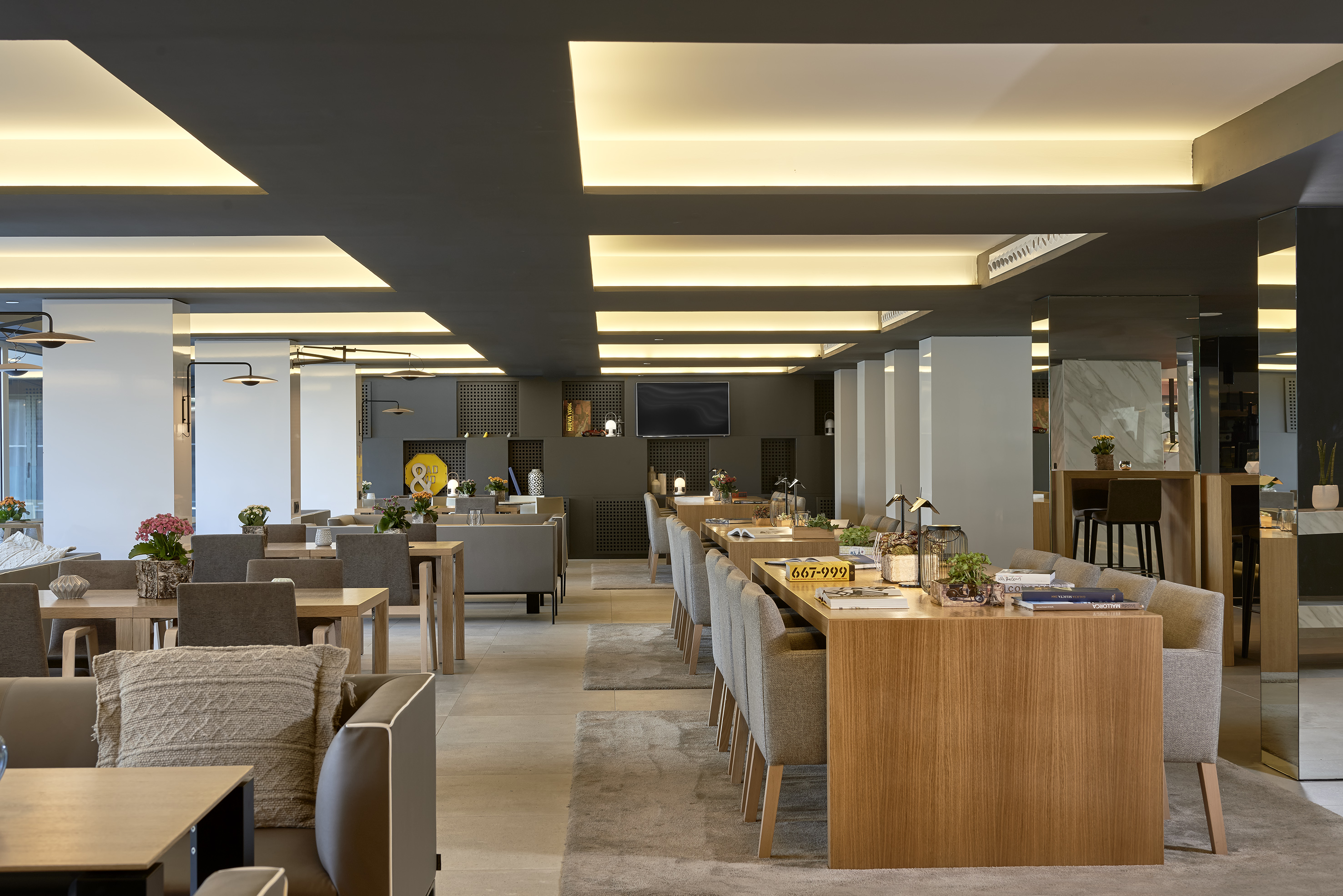 Modern lounge restaurant with wooden tables, grey seating, and warm ambient lighting.