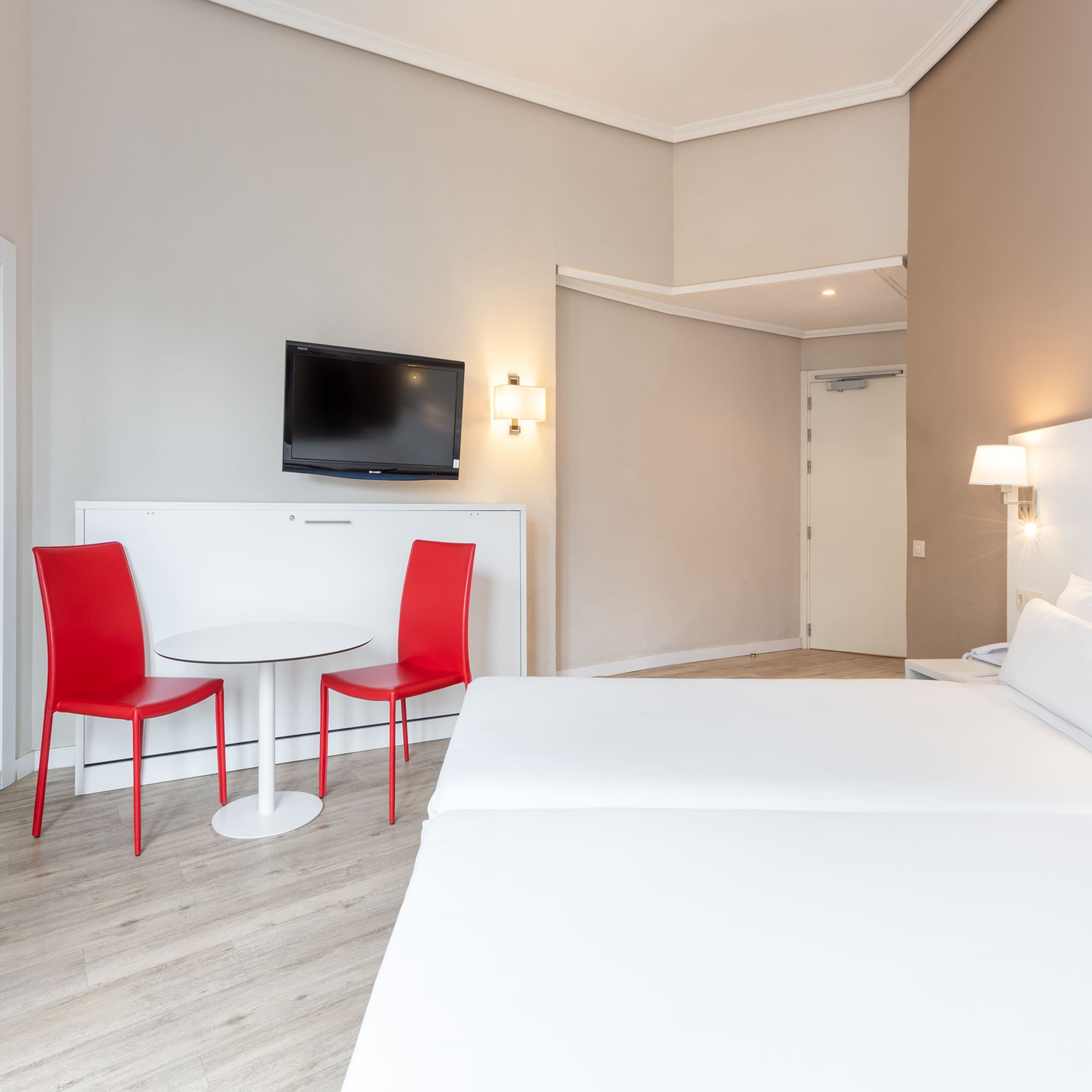 a room with a bed and a table and chairs