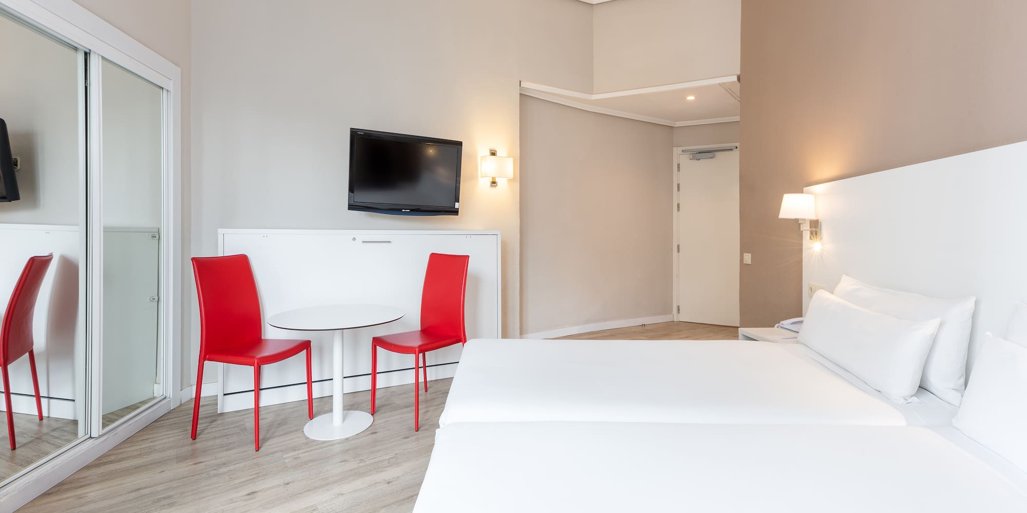 a room with a bed and a table and chairs