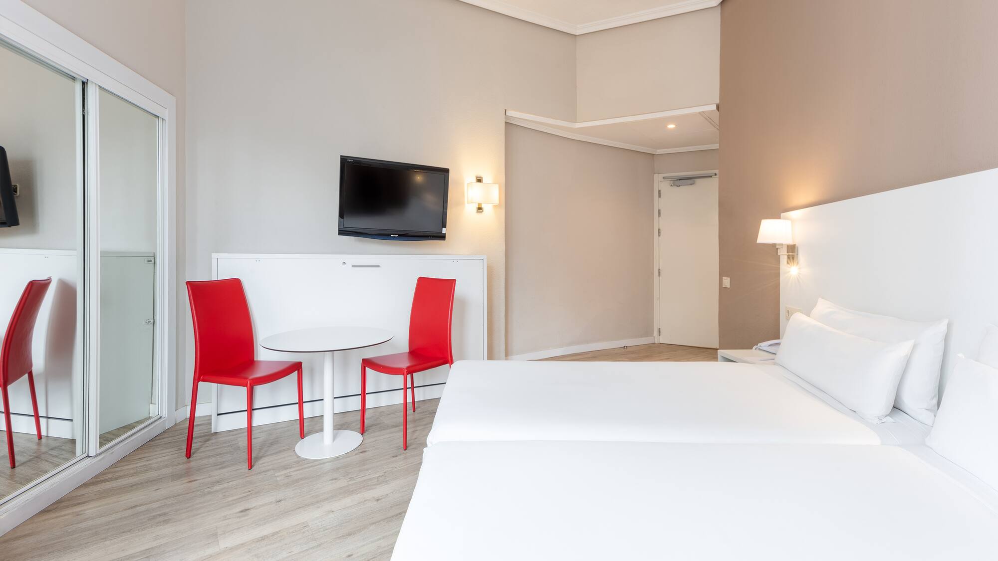 a room with a bed and a table and chairs