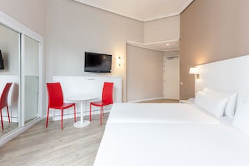 a room with a bed and a table and chairs