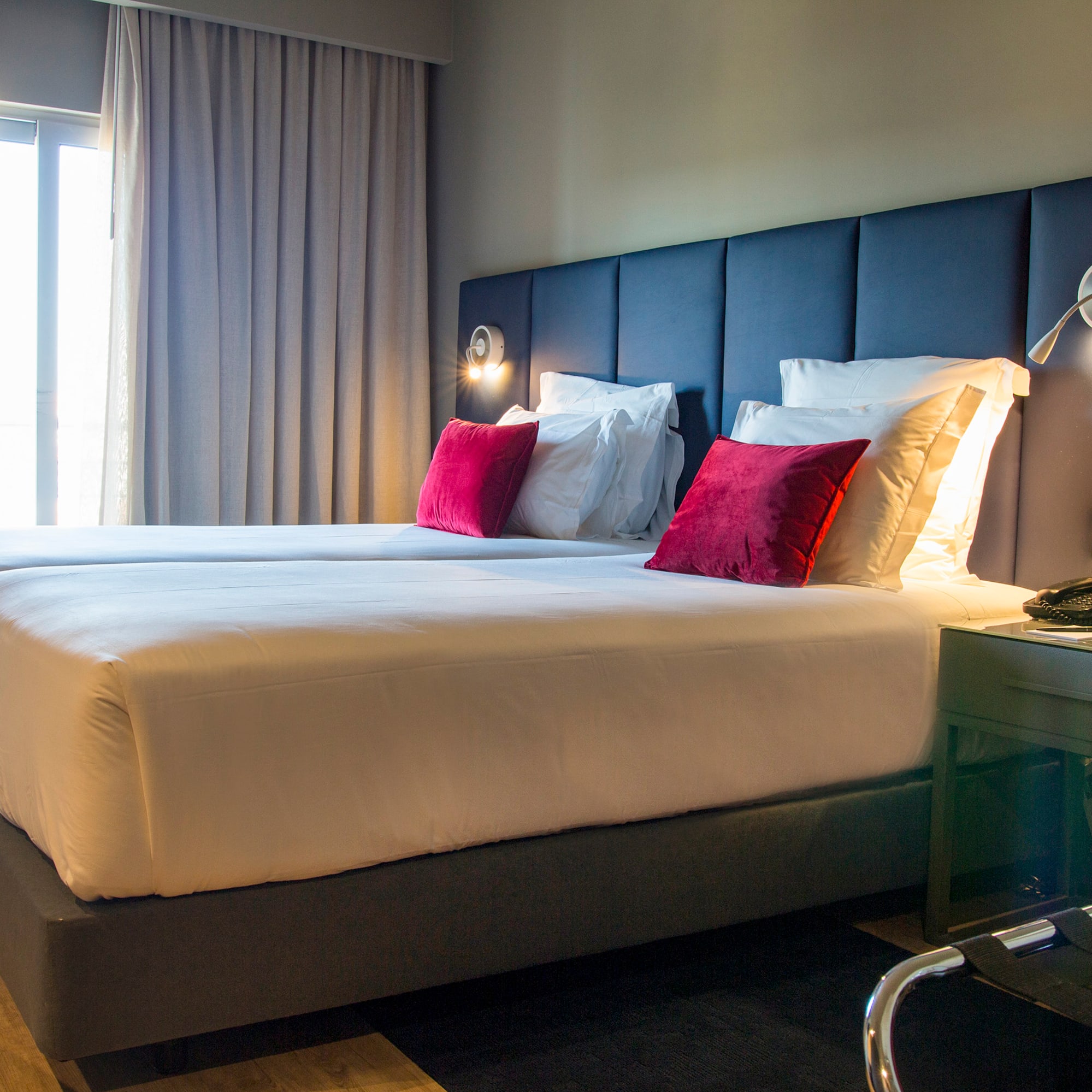 a bed with pillows and a lamp in a hotel room