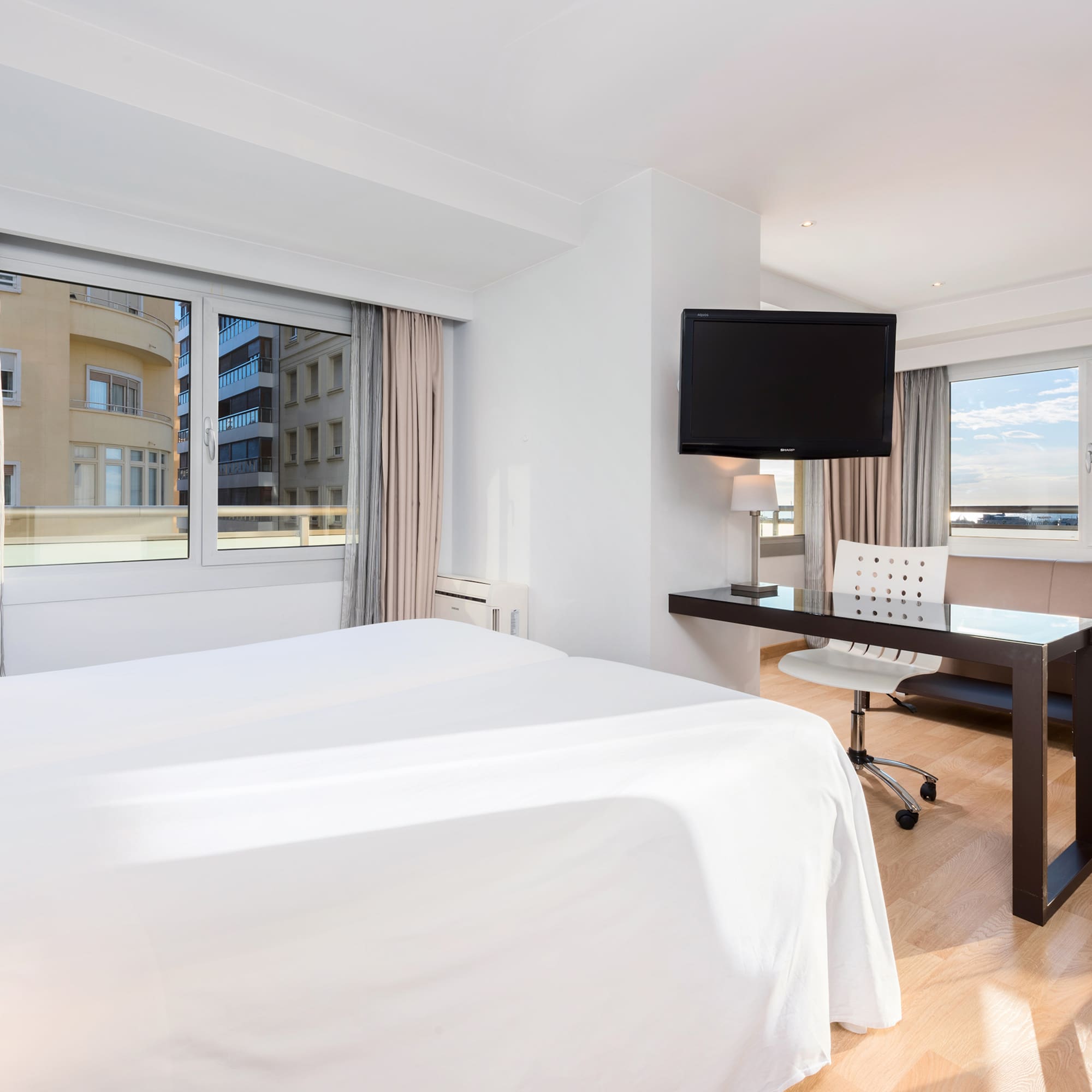 a room with a bed and a desk and a television