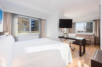 a room with a bed and a desk and a television