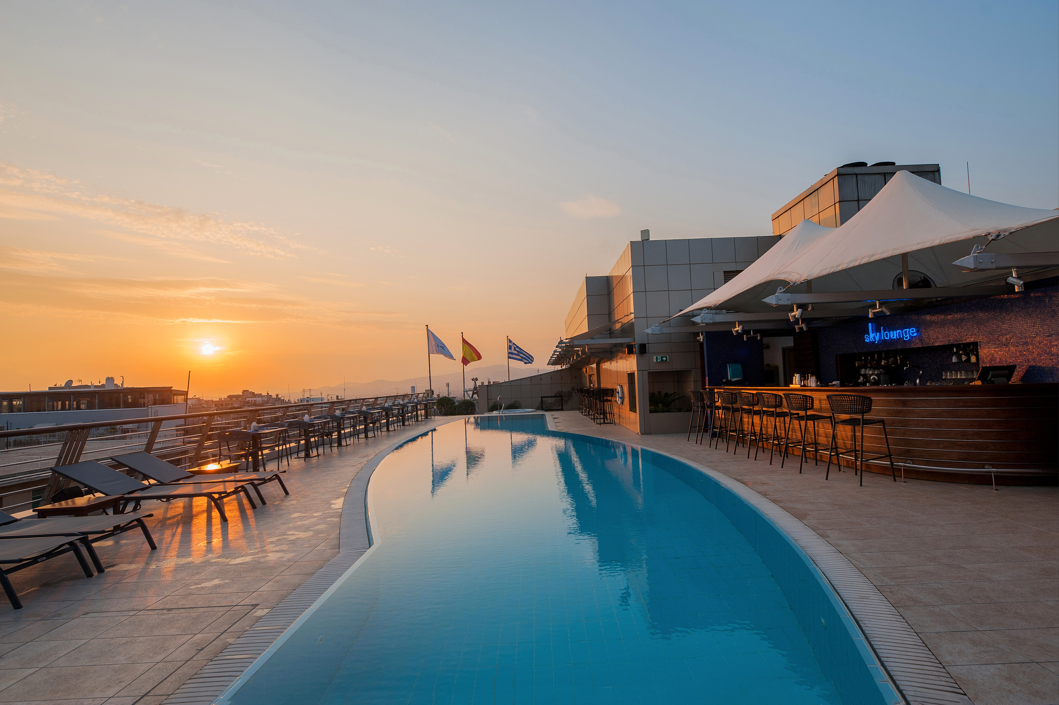 a pool with tables and chairs on a rooftop