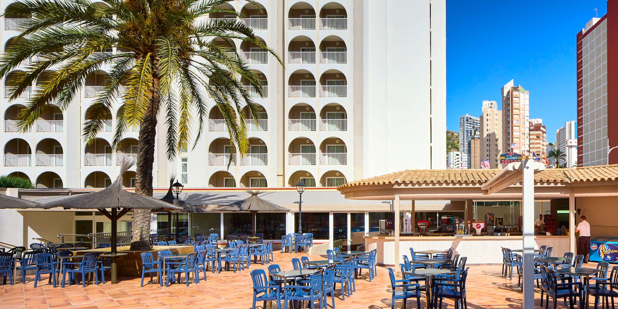 a group of blue chairs and tables outside a building