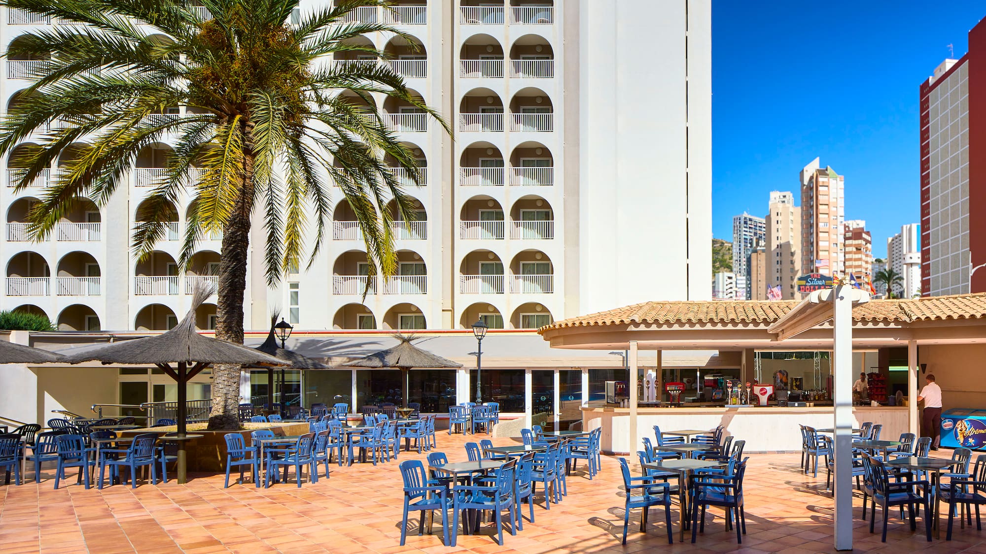 a group of blue chairs and tables outside a building