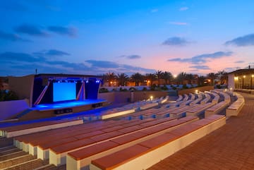 an outdoor theater with a stage and a blue screen