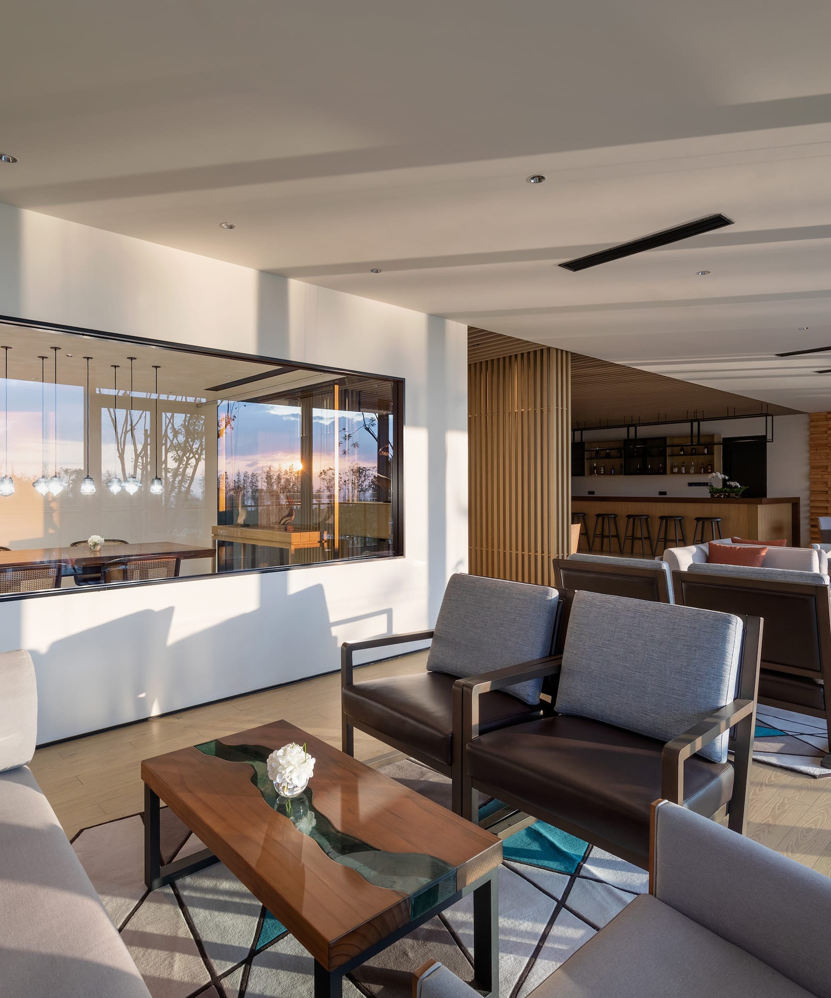 a room with a large glass wall and a couch and chairs