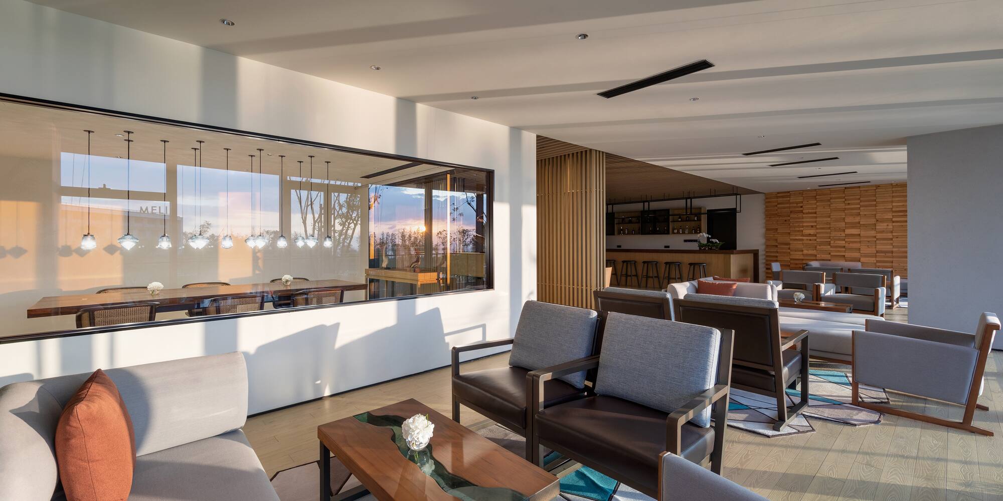 a room with a large glass wall and a couch and chairs