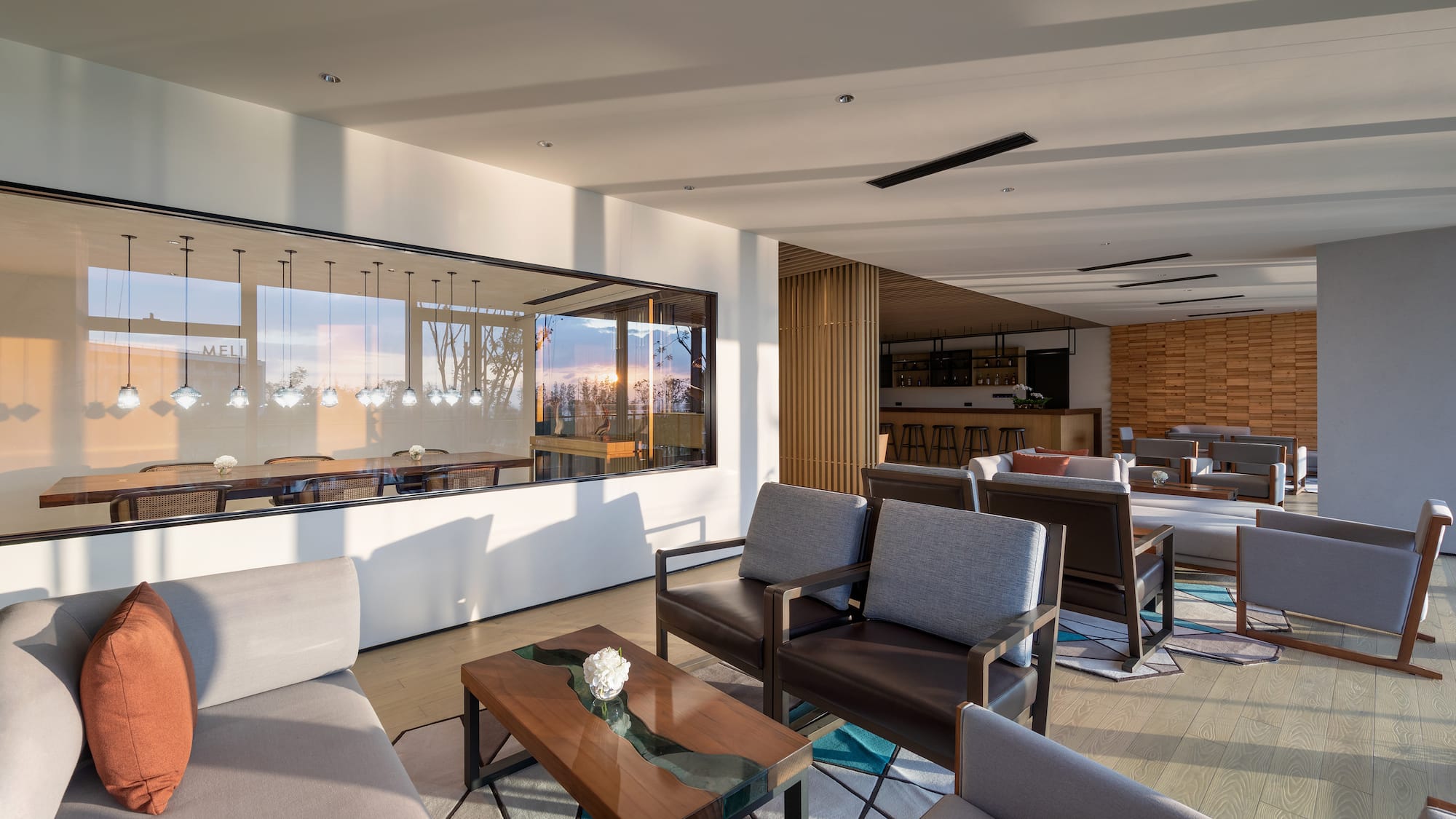 a room with a large glass wall and a couch and chairs