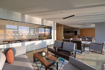 a room with a large glass wall and a couch and chairs