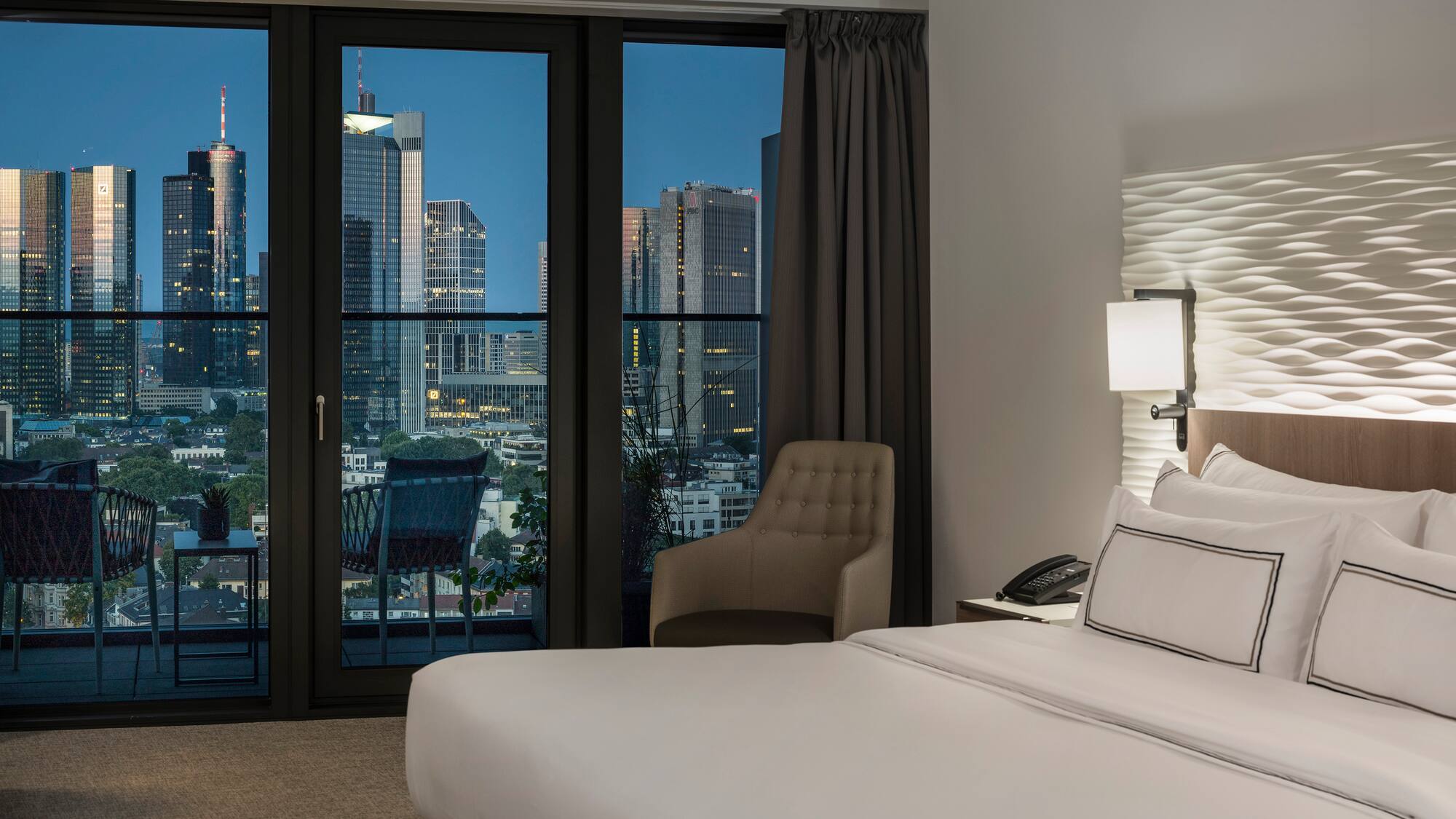 a bedroom with a large window and a bed