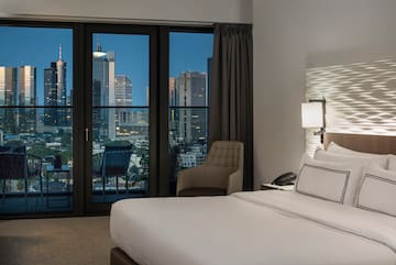 a bedroom with a large window and a bed