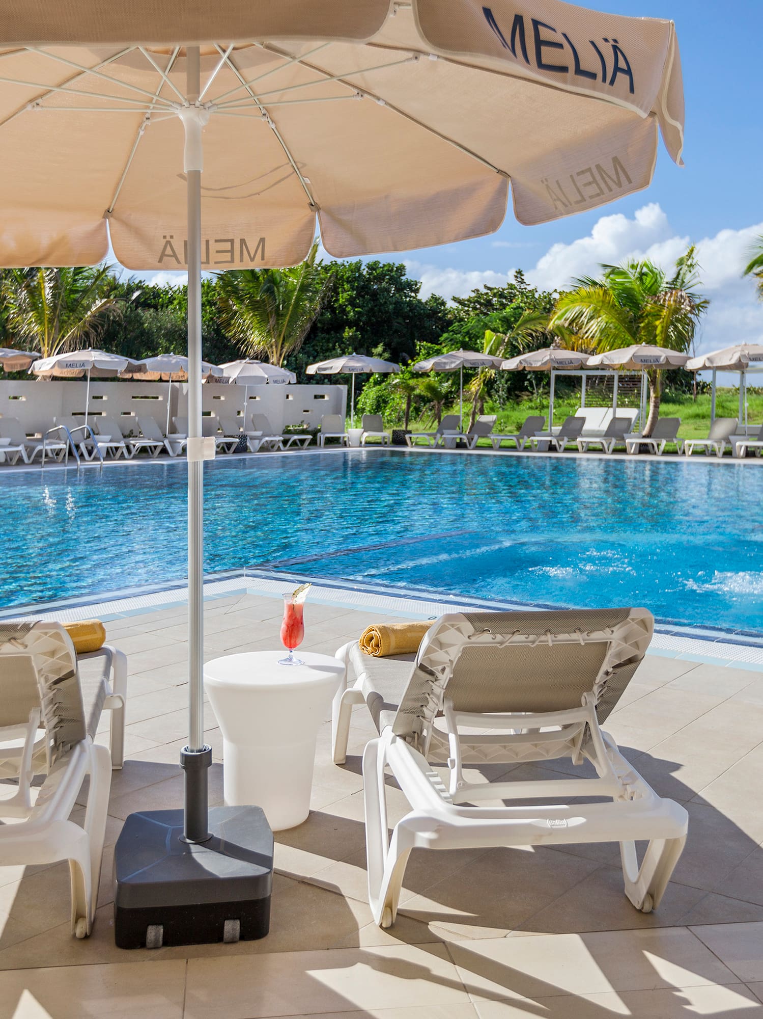 a pool with chairs and umbrellas