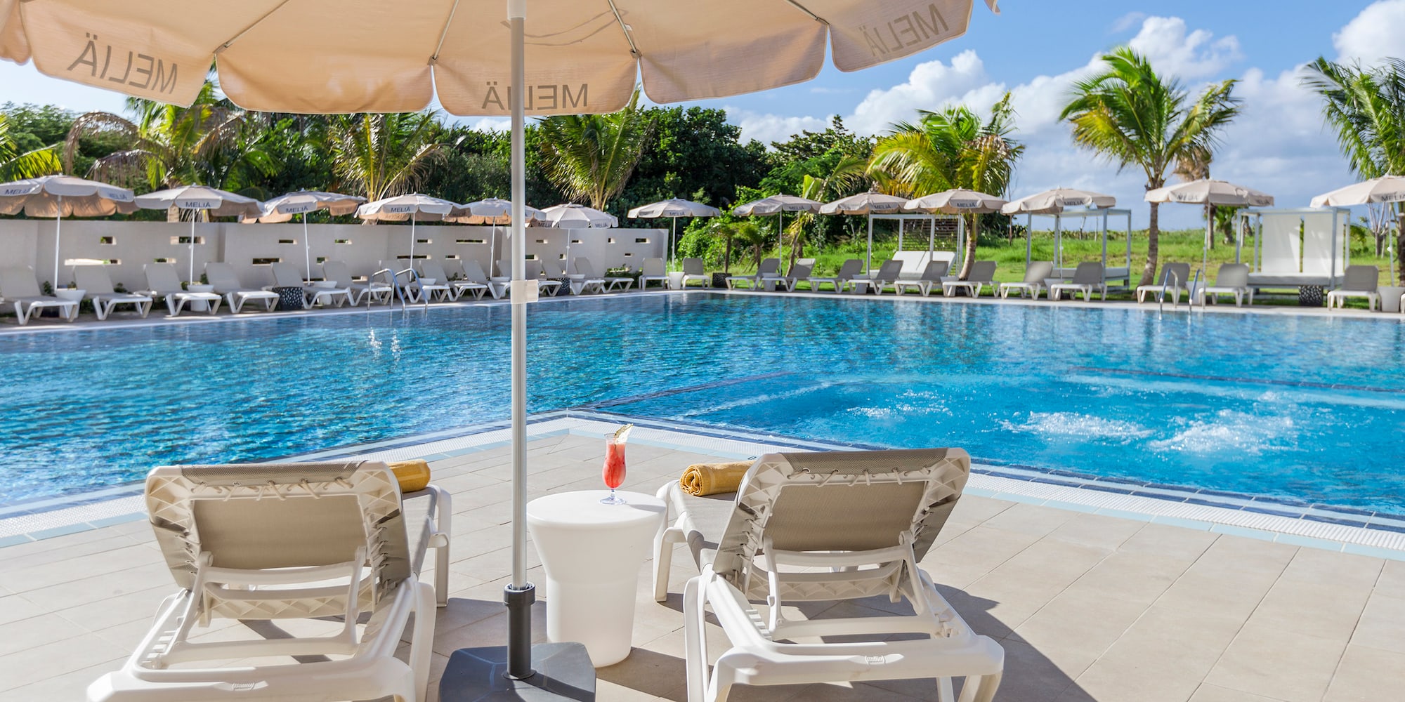 a pool with chairs and umbrellas