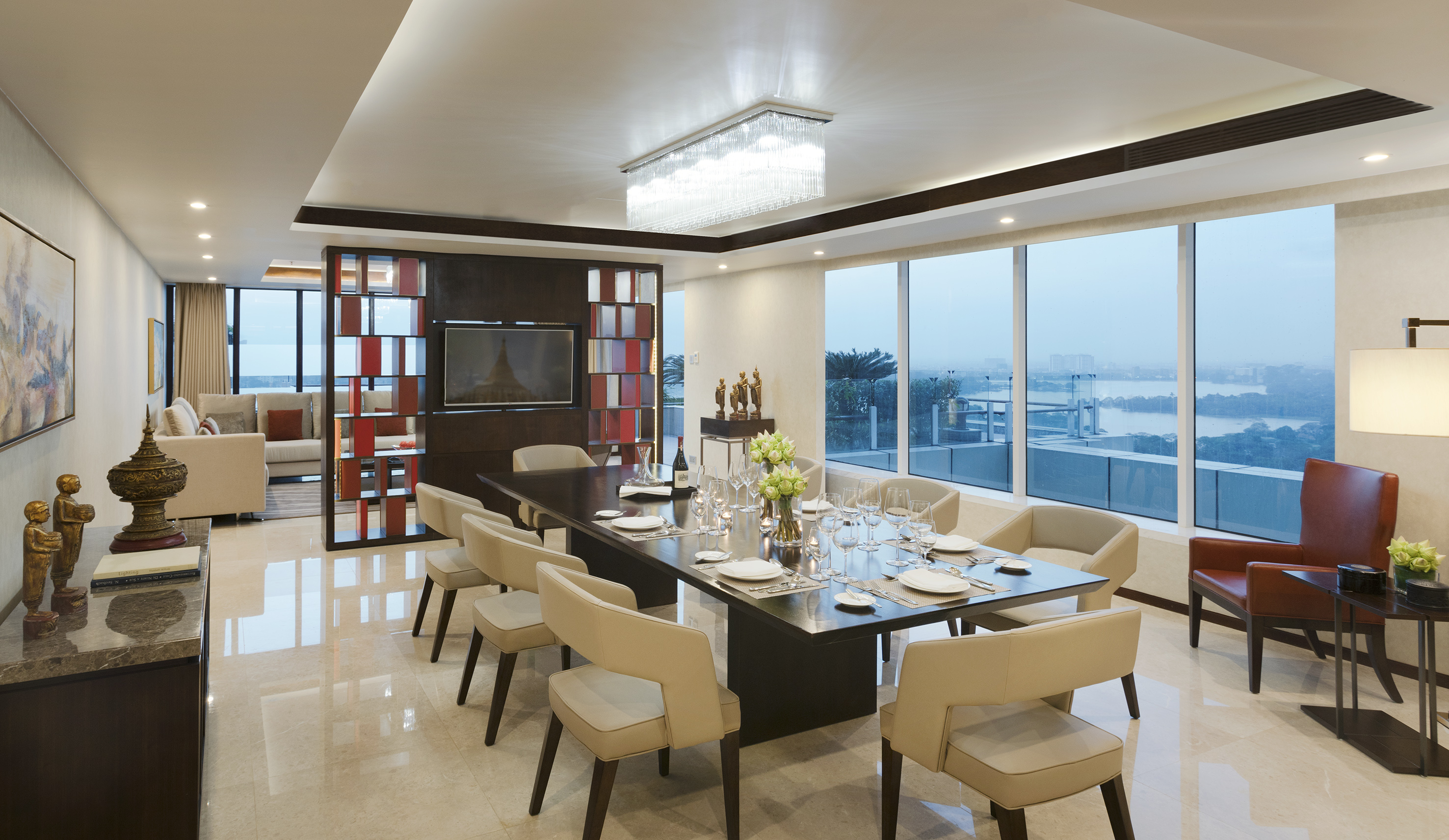 Modern luxury dining room with large table, cream chairs, and cityscape view.