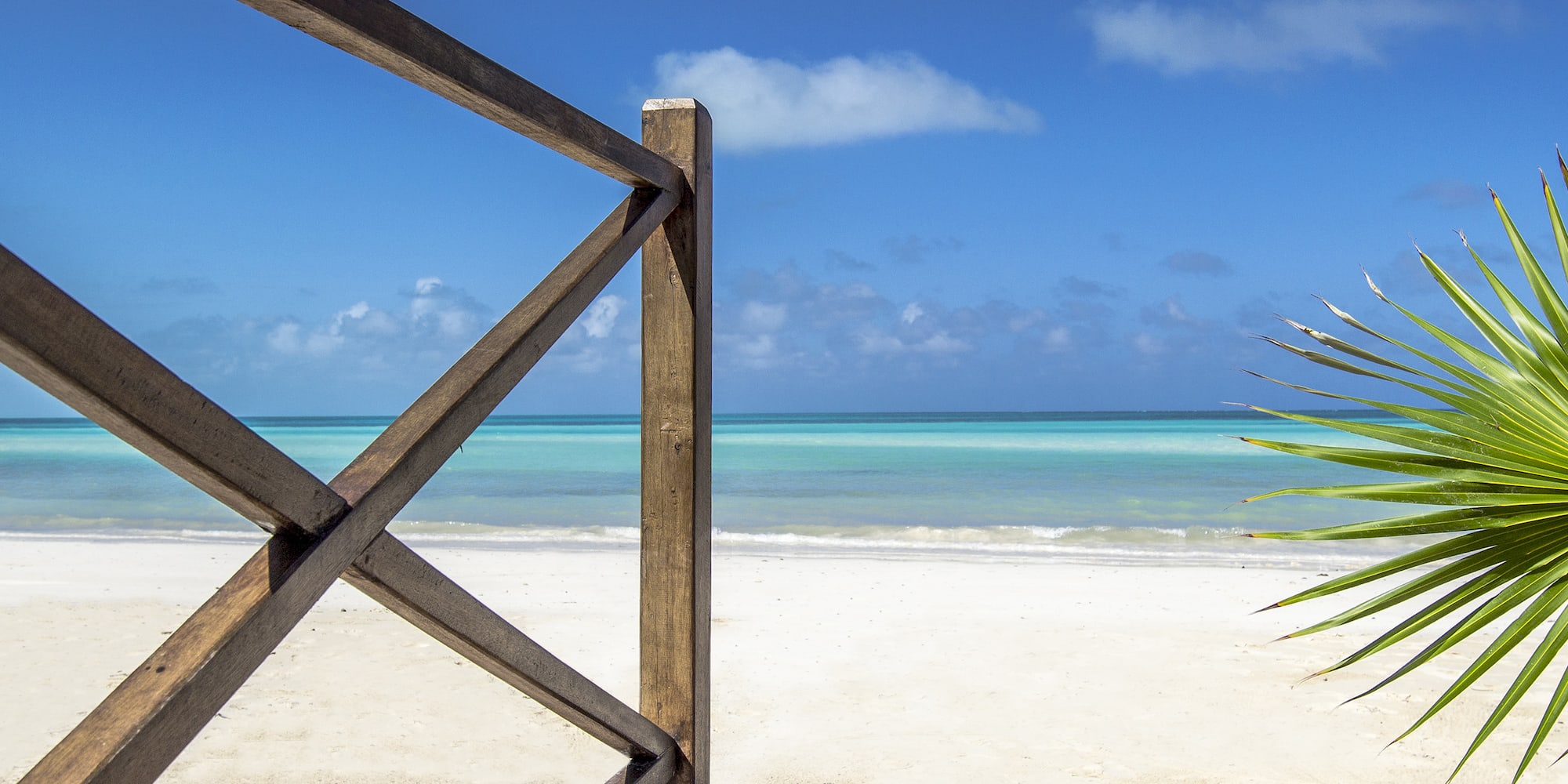a wooden fence on a beach