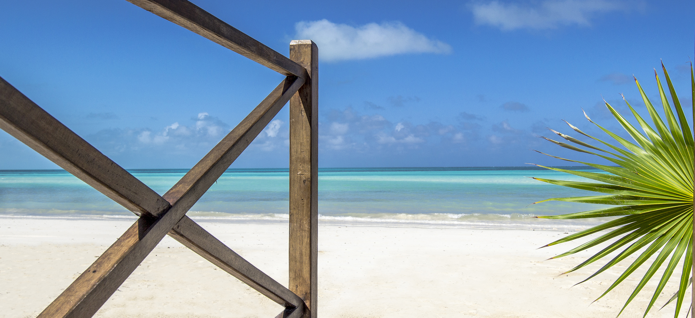 a wooden fence on a beach