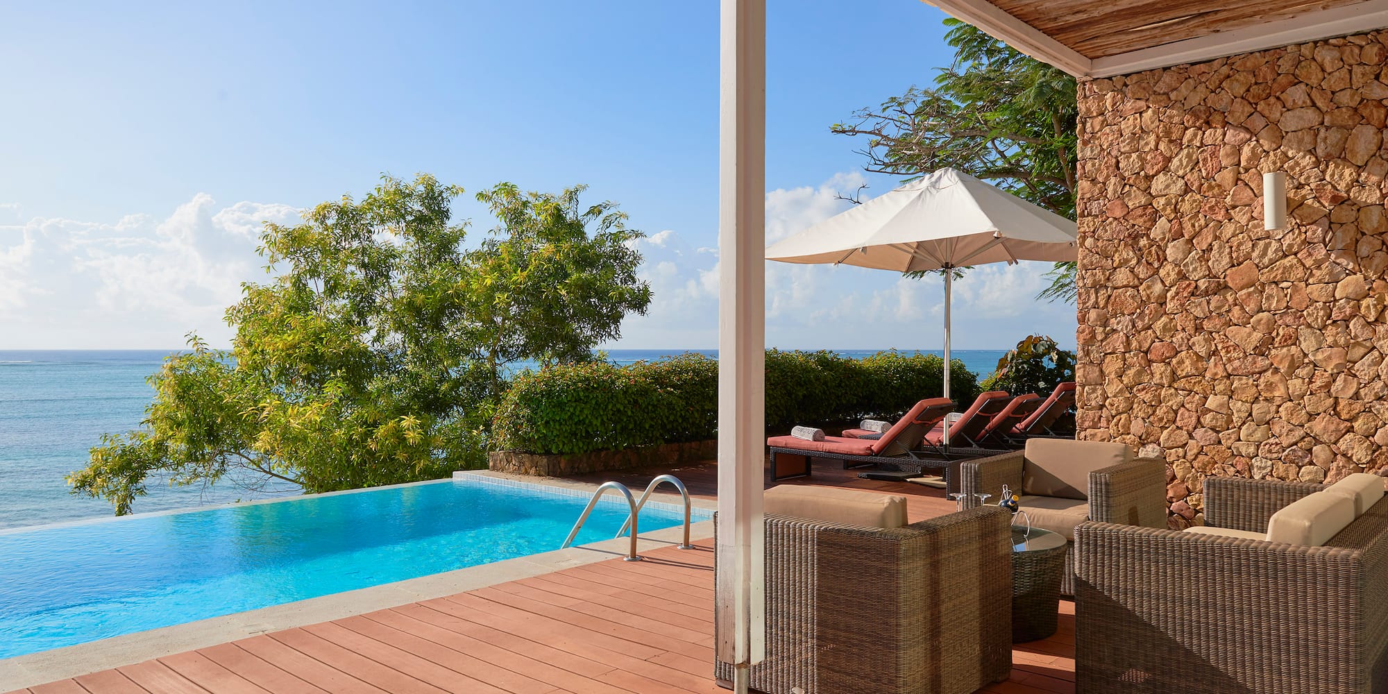 a pool with chairs and umbrella on a deck