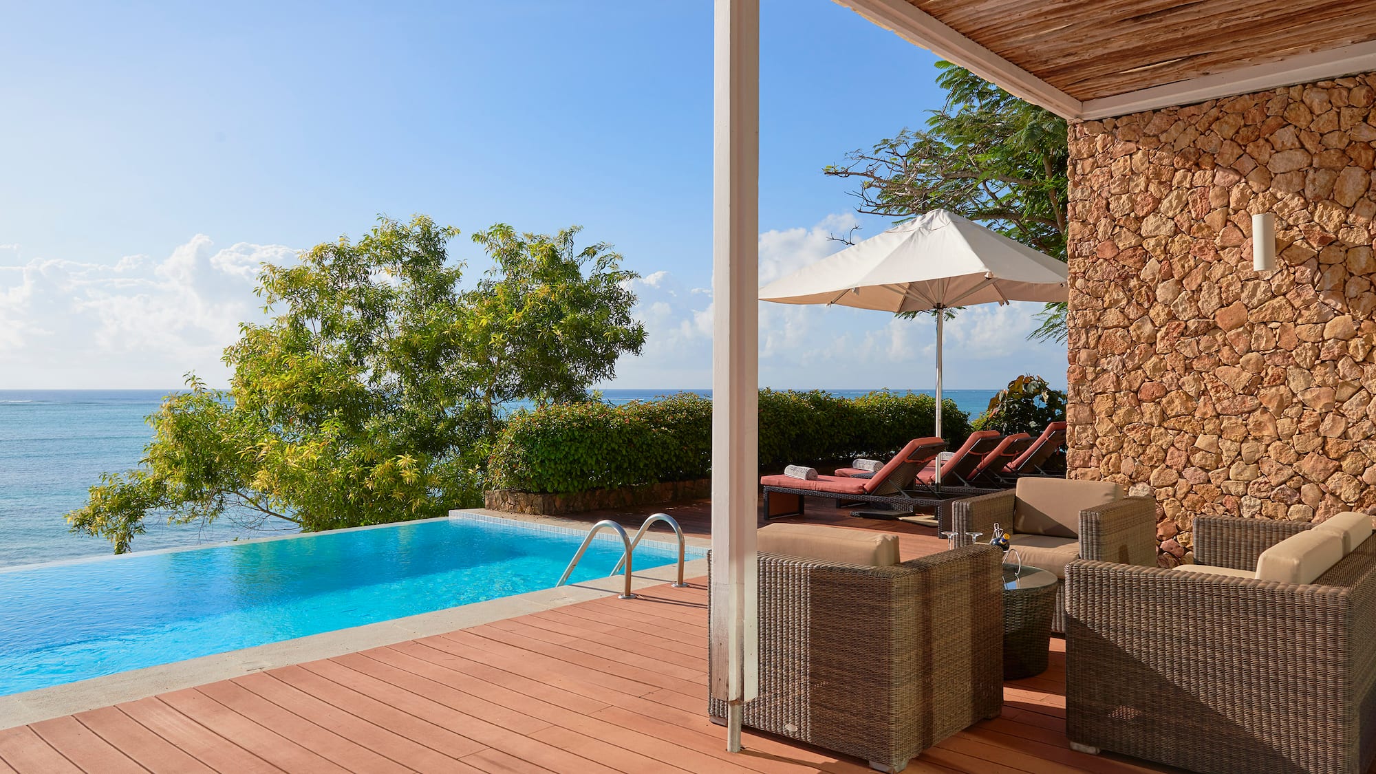 a pool with chairs and umbrella on a deck