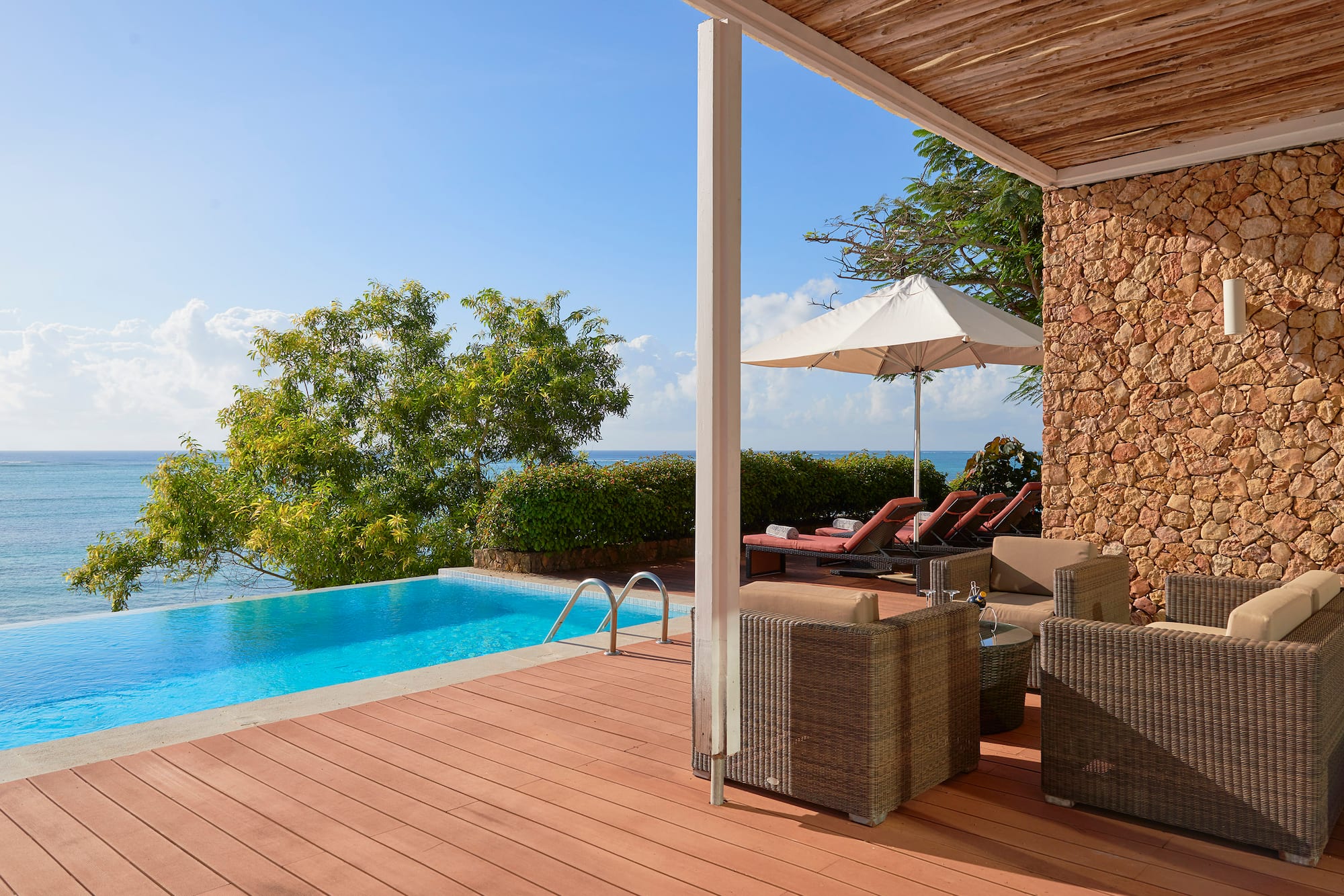 a pool with chairs and umbrella on a deck