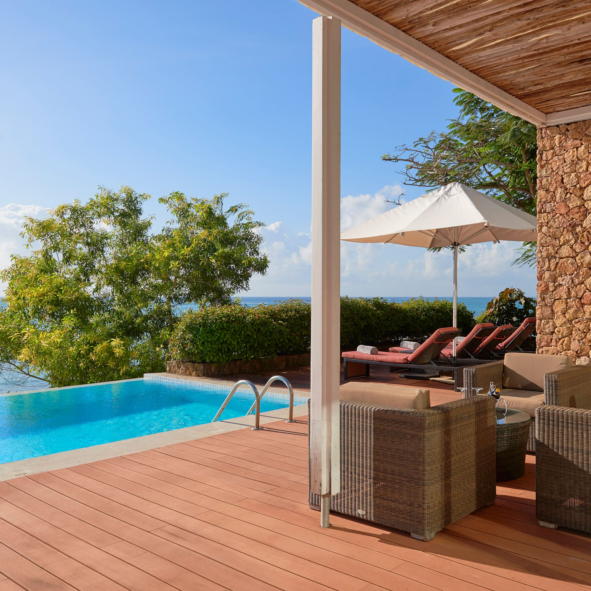 a pool with chairs and umbrella on a deck