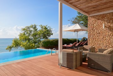 a pool with chairs and umbrella on a deck