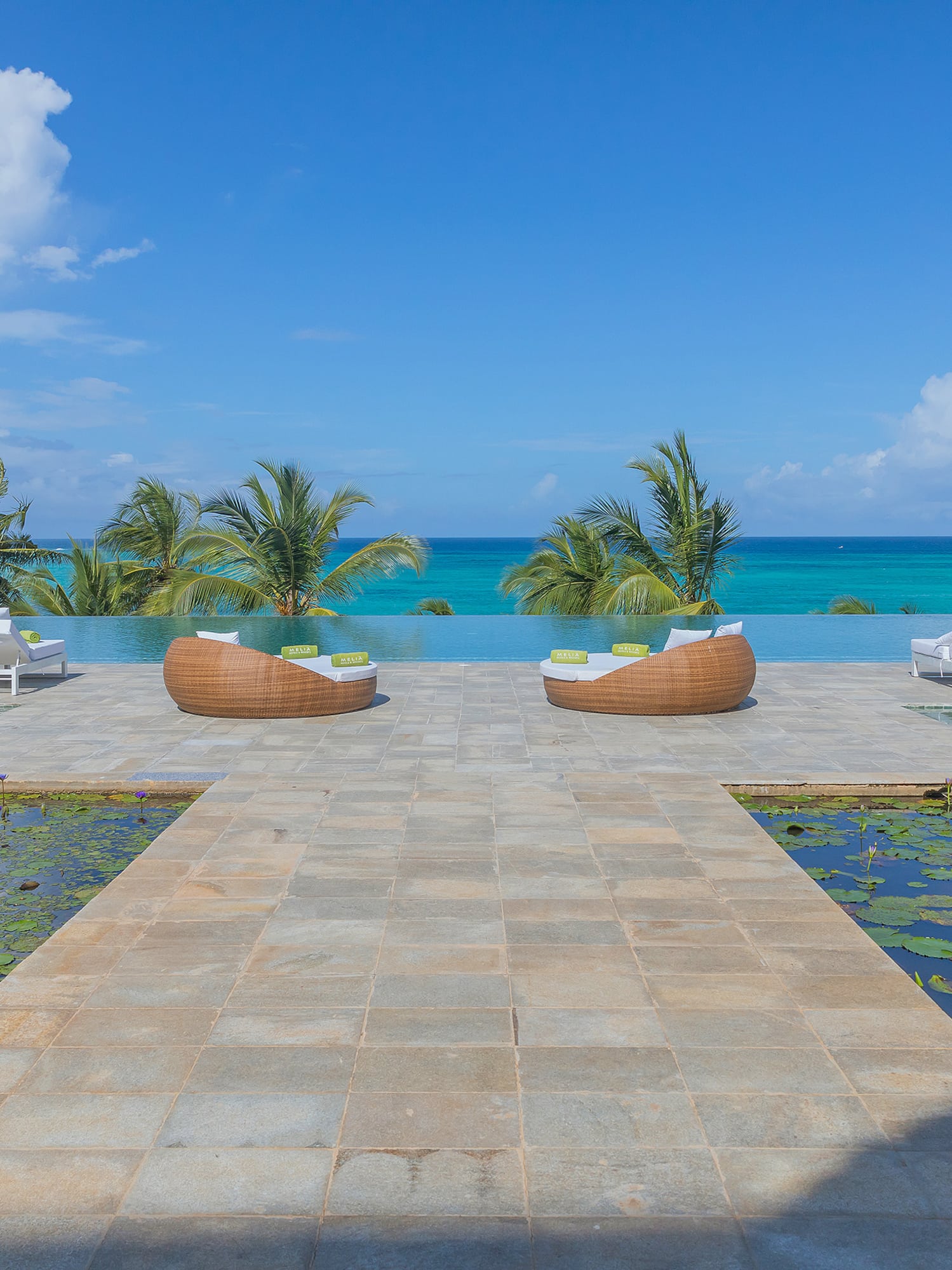 a pool with lounge chairs and water in the background
