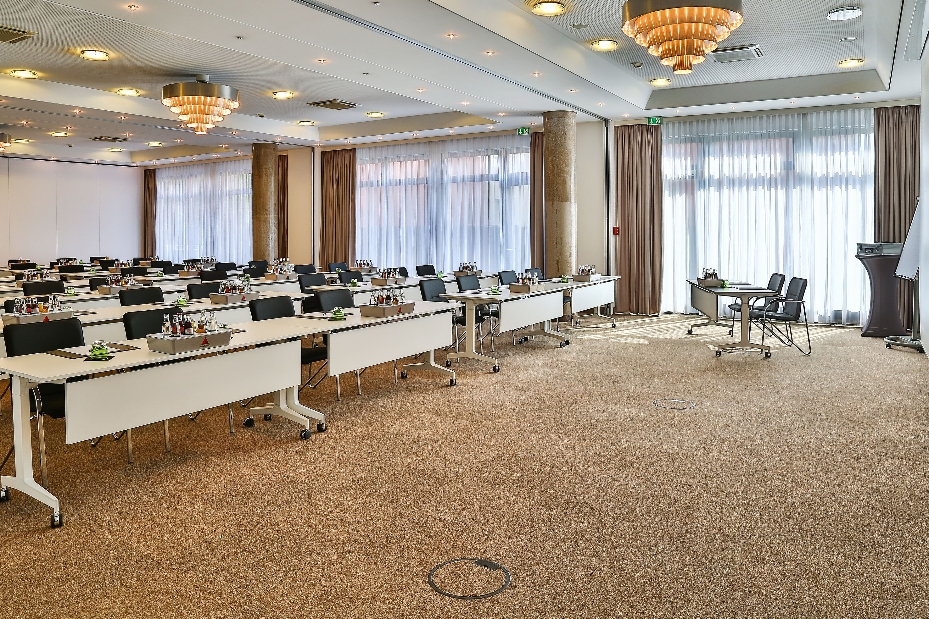Fully equipped meeting room with tables, chairs, drinks, and natural light.