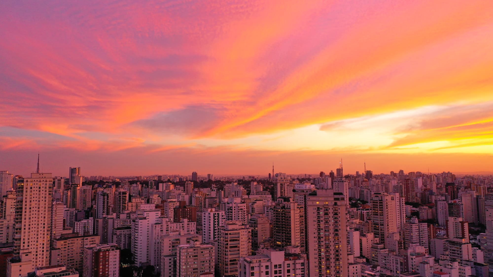 a city skyline with a pink and orange sky