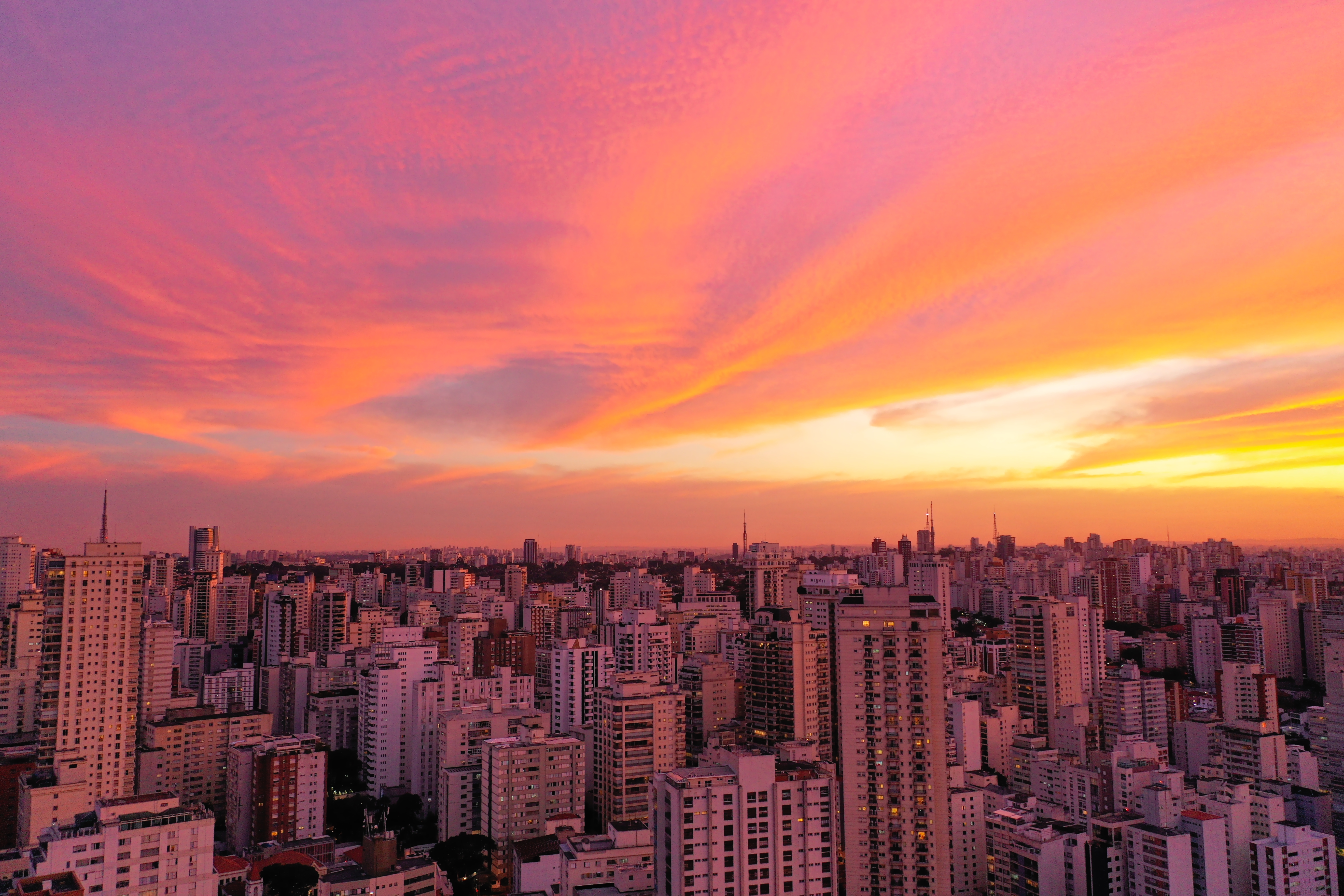a city skyline with a pink and orange sky