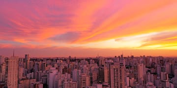 a city skyline with a pink and orange sky