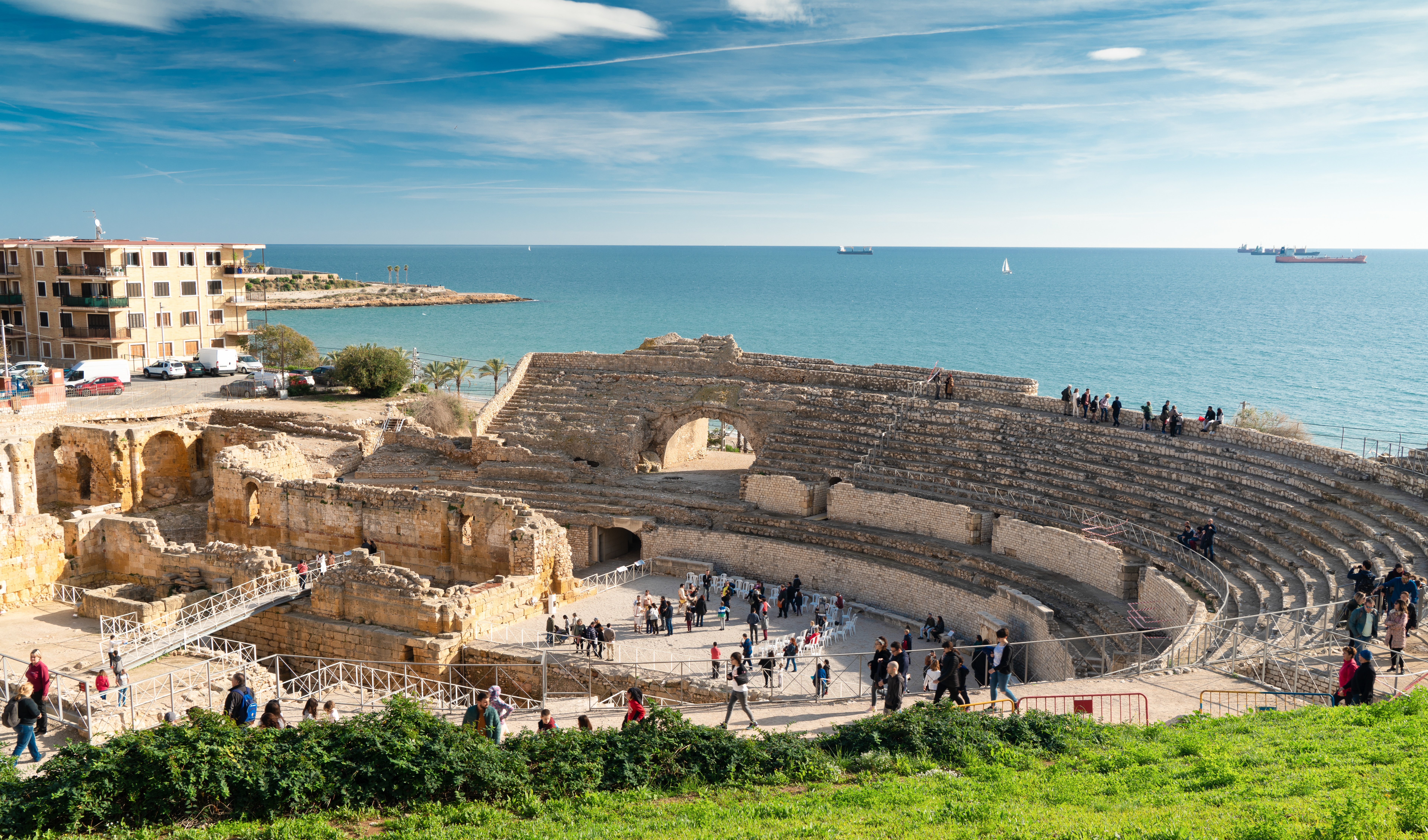 Anfiteatro romano de Tarragona a orillas del Mediterráneo, con visitantes.