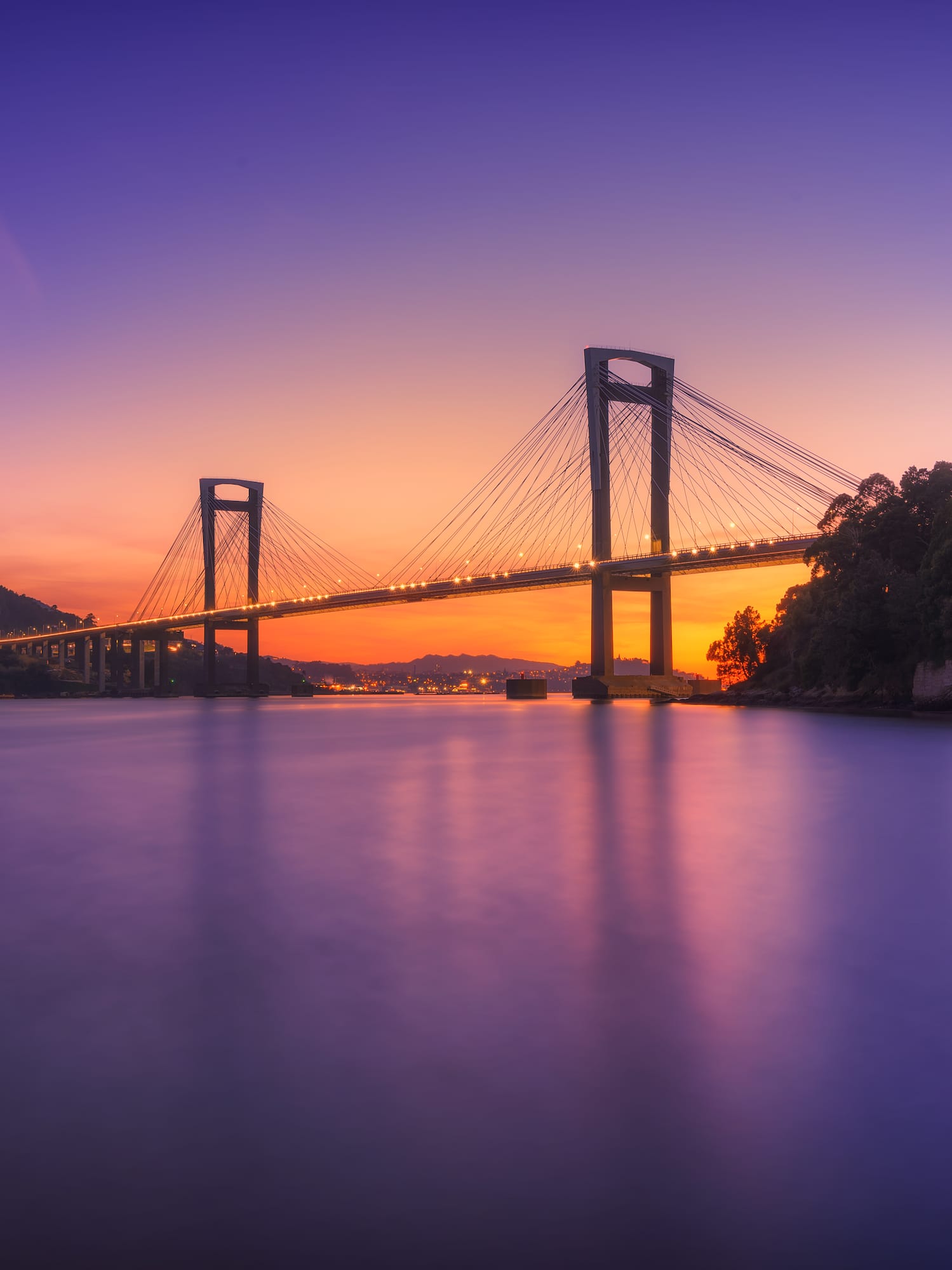 a bridge over water at sunset