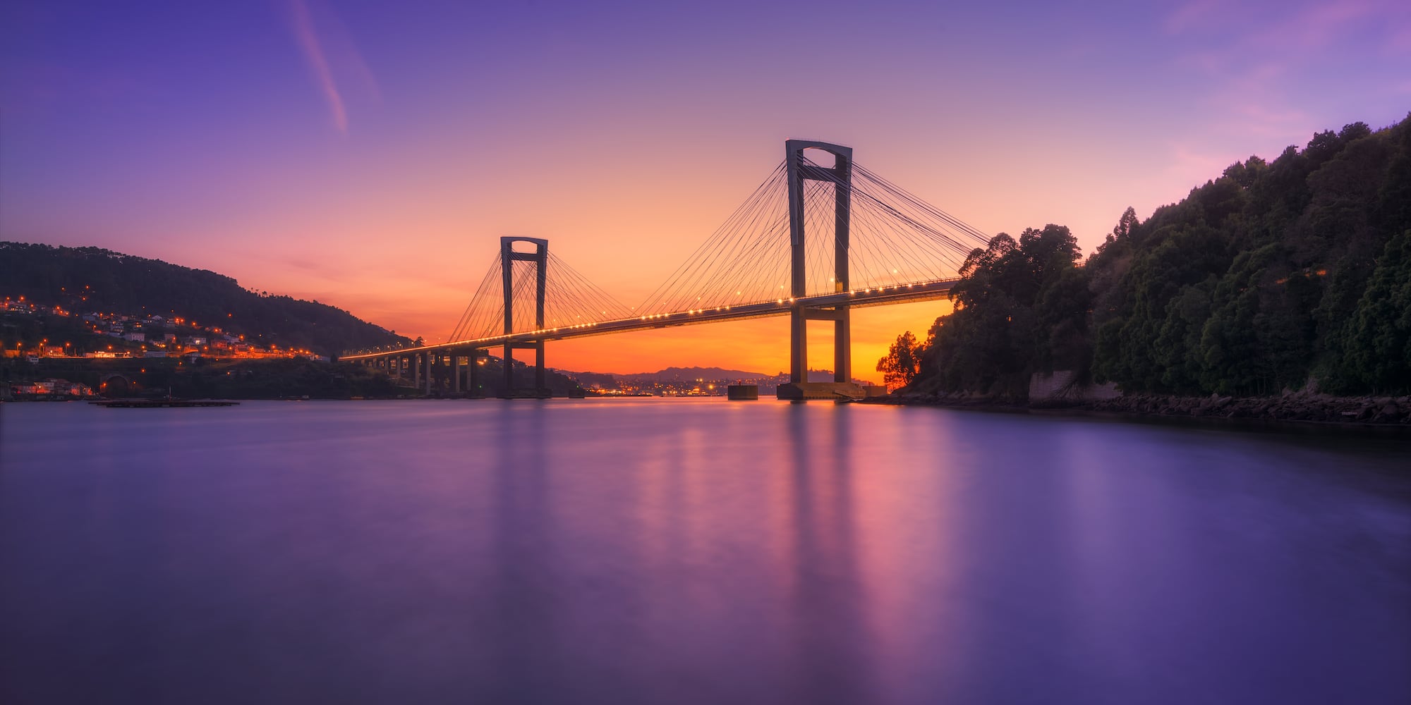 a bridge over water at sunset