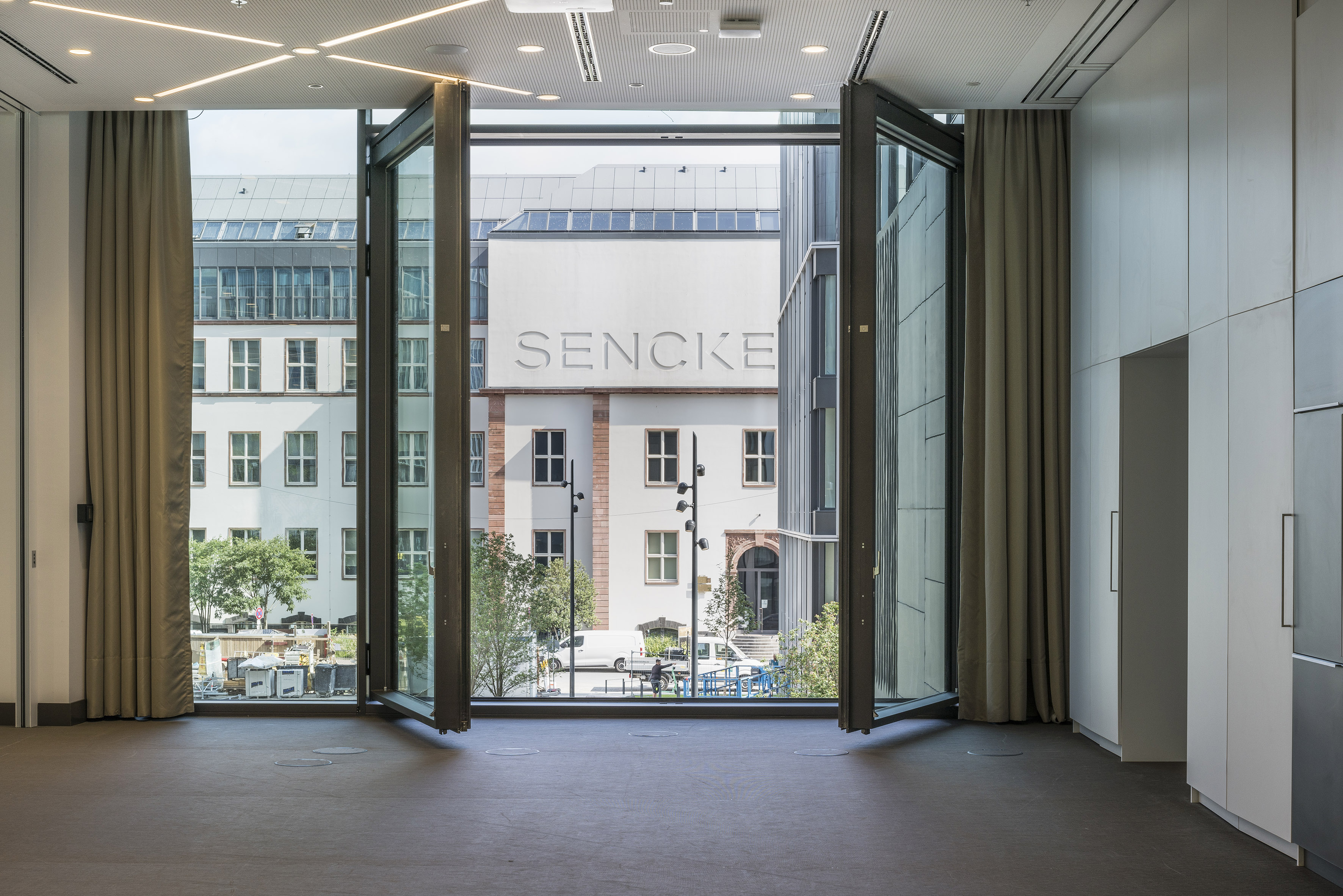 Modern space, open glass folding doors, city view of SENCKE building.