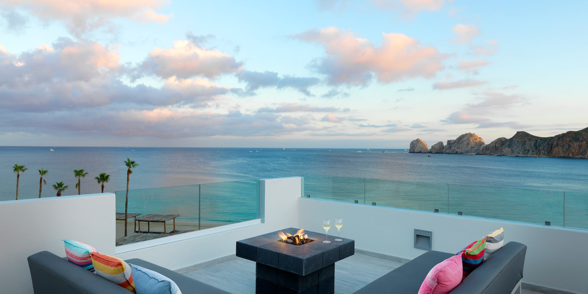 a patio with a fire pit overlooking the ocean